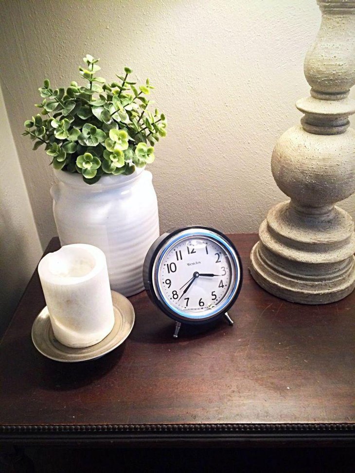 An assorted display of candle vase clock and lamp looks elegant