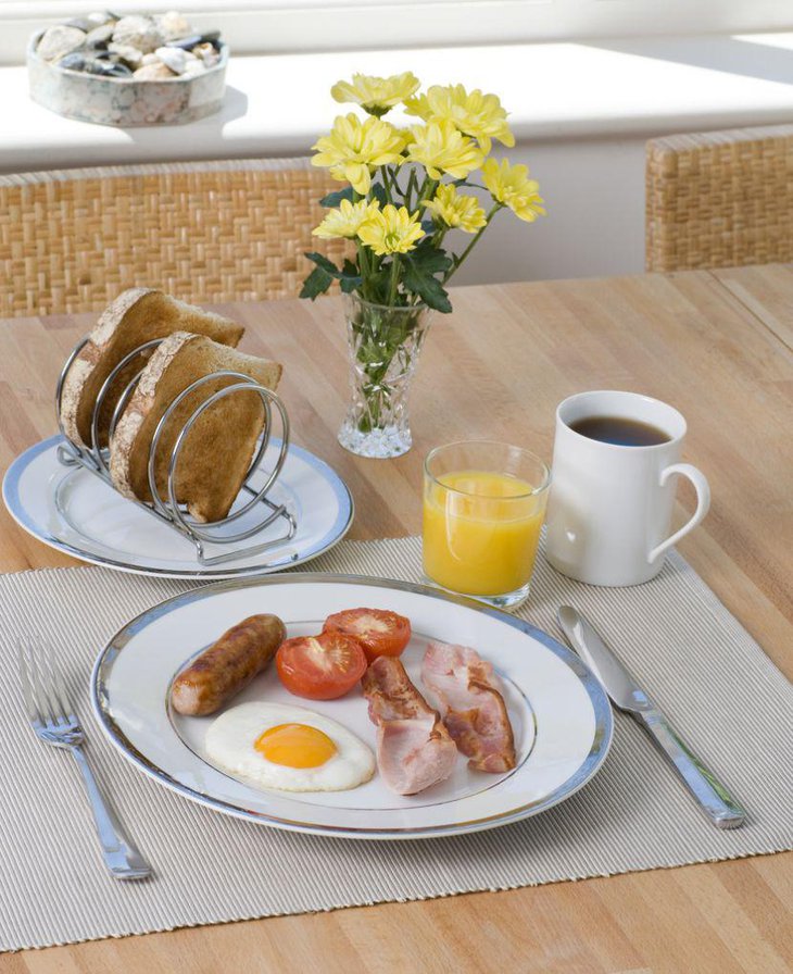 An elegant breakfast table decked up with basics and yellow flowers