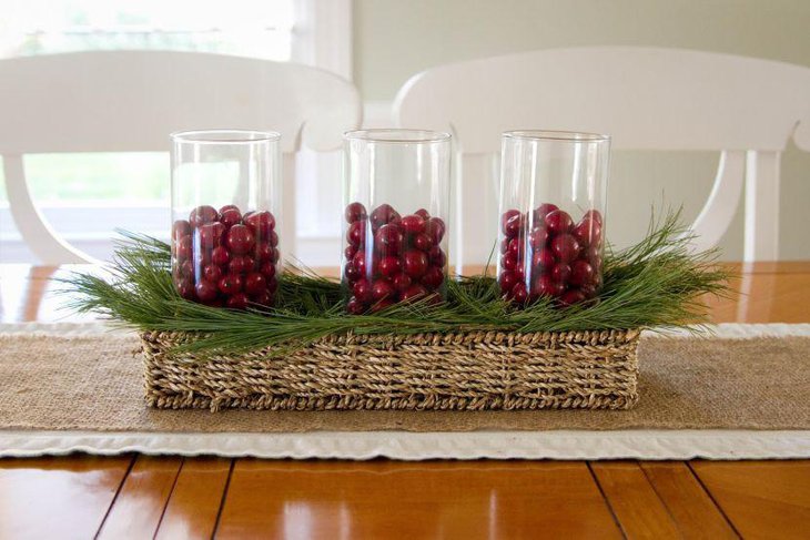 Awesome dining table centerpiece with glasses filled with red berries and basket