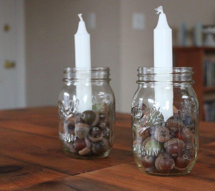 Awesome Glass Holder With Candles and Acorns As Table Centerpiece