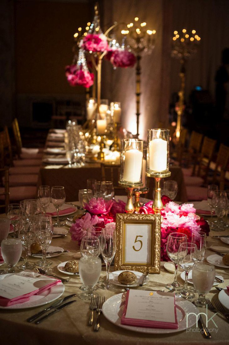 Awesome wedding table decor with golden accented candleholders and frame
