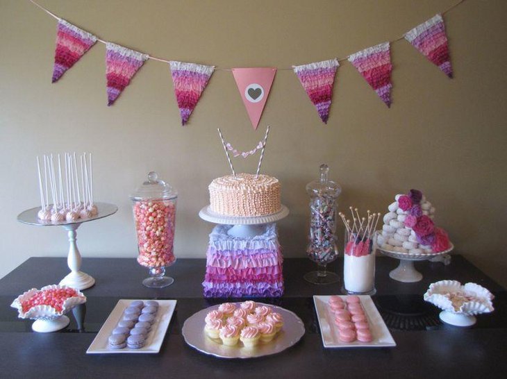 Baby shower dessert table decorations with pink buntings pink frilly cake stand flowers and cupcakes
