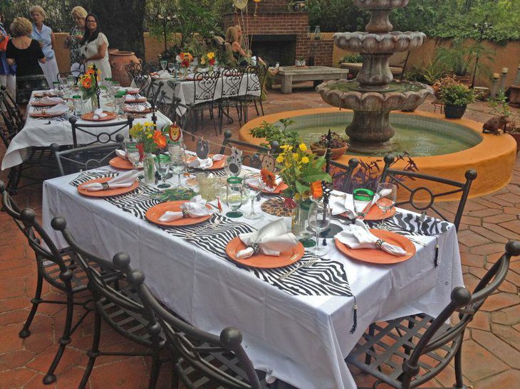 Baby shower jungle theme guest table set up with zebra print coasters and animal cuttings