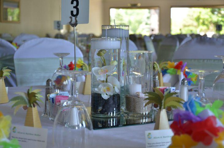 Beach themed wedding centerpiece with jars filled with candles and sand