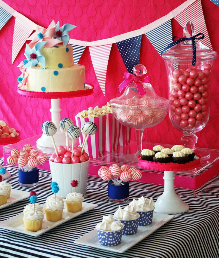 Birthday party dessert table decor with cake decorated with pinwheels and cupcakes