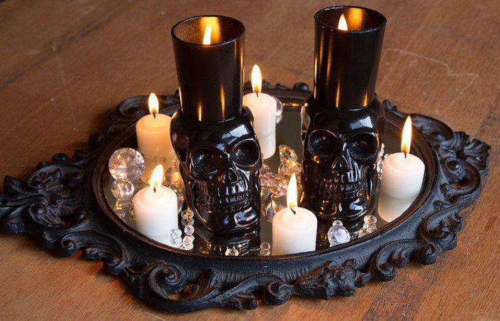 Black skulls with candles and votives decorated on a black tray