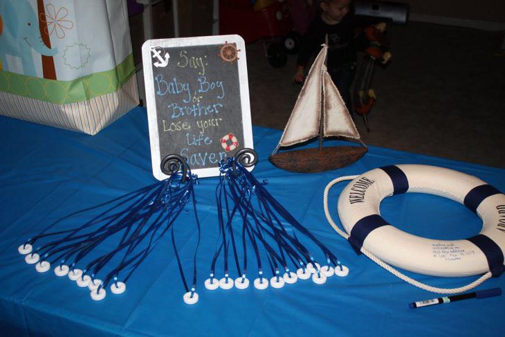 Blue nautical themed boy baby shower decor with boat and tube