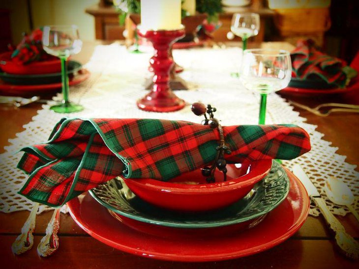 Christmas Table Decoration With Red Plates and Silver Spoons