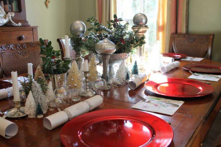 Christmas Table Setting With Silver Decorative Pieces and Red Plates