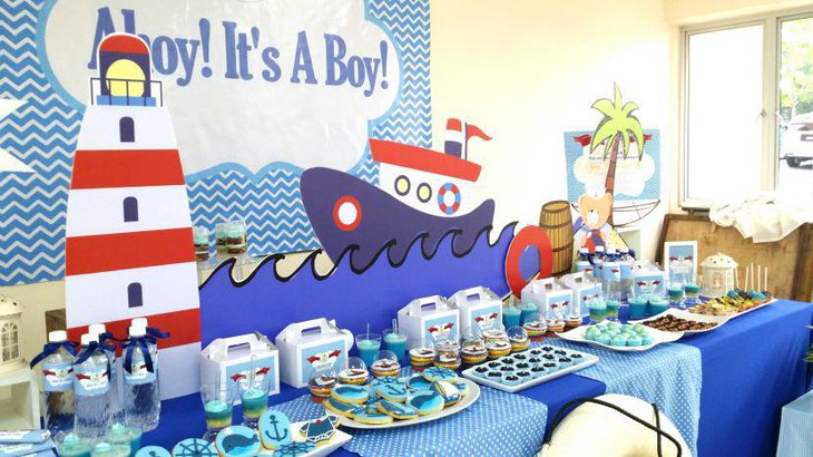 Cool nautical boy baby shower decor with sea and sailboat designs in the backdrop along with anchor cookies 1