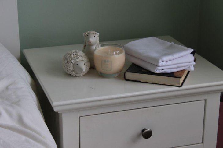 Cute bedside table decor with white animal statues and candle
