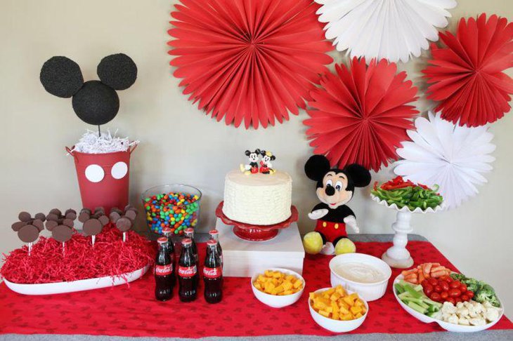 Cute Mickey and Minie Mouse topped cake decor on birthday table