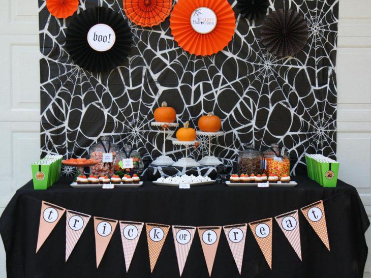 Cute pumpkins on white holders on Halloween table