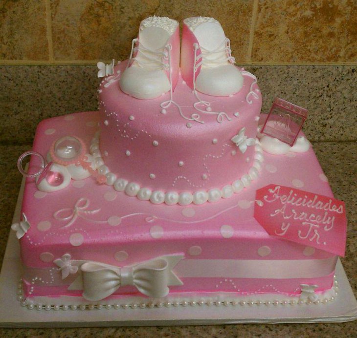 Delicious pink princess baby shower cake with shoes and pearls designing