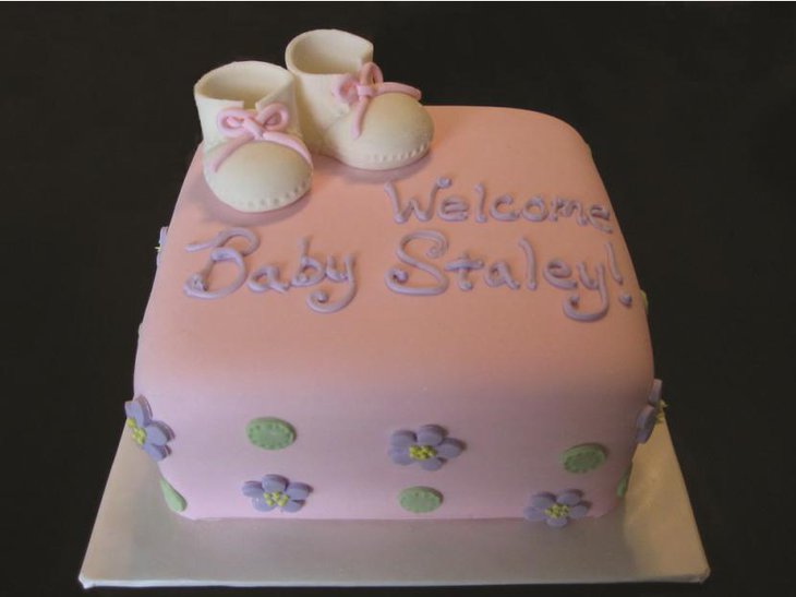 Edible cake decorated with boots and flowers for baby shower centerpieces