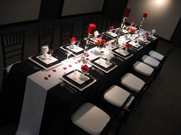 Elegant black and white wedding table setting with red accents