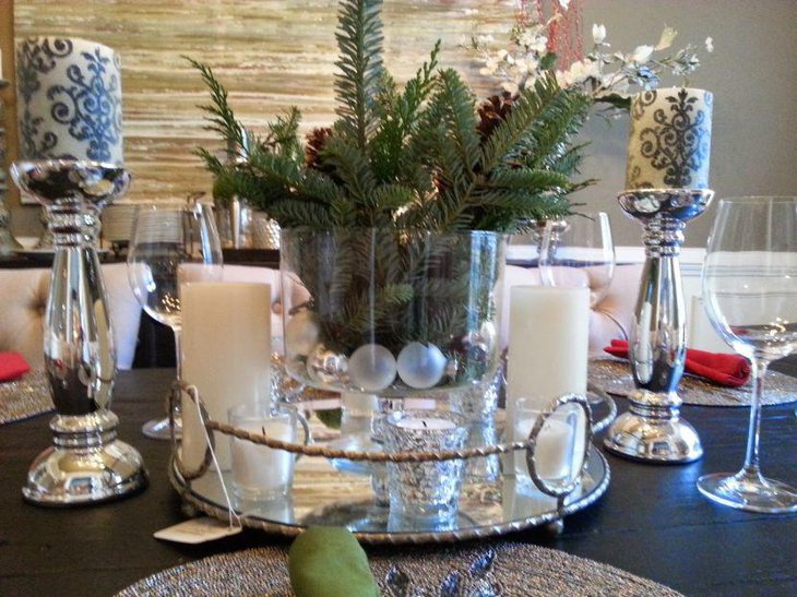 Eye grabbing silver tray centerpiece with vase filled with greens and votives