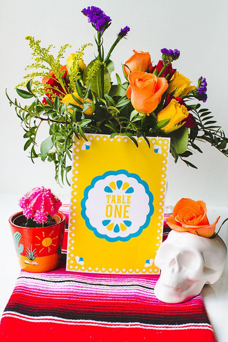 Flowers and papel picado table number decor on table