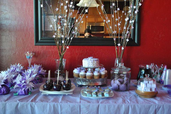 Glamorous birthday party table decoration with purple favors and cookies