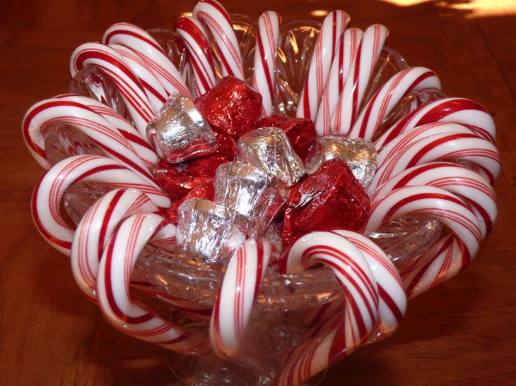 Glass bowl filled with red and white chocolates and candies as table centerpiece for weddings