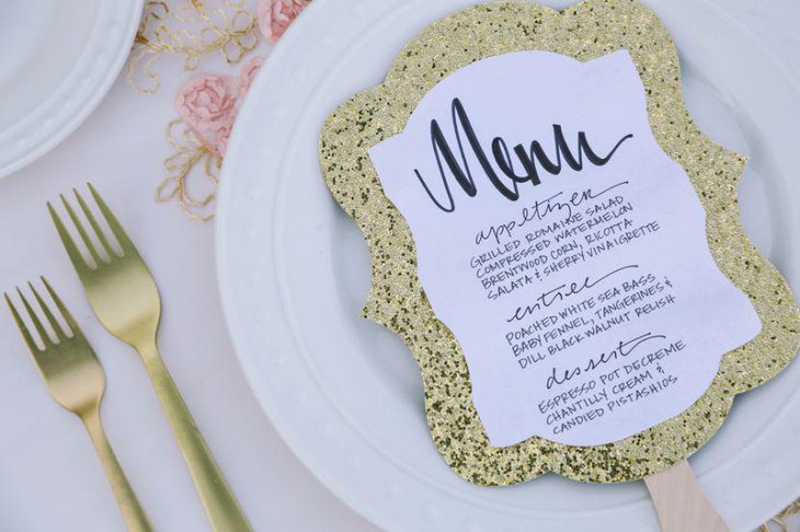 Glittery golden menu card decoration on wedding table