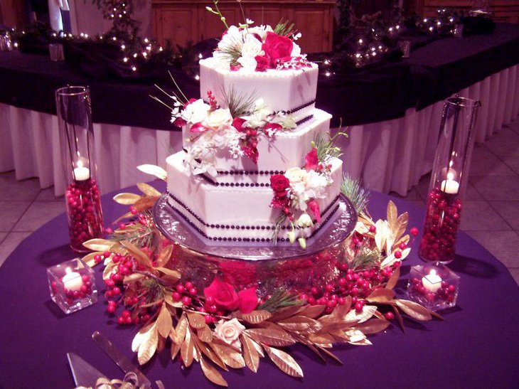 Gorgeous wedding cake table decor using berries and candle jars