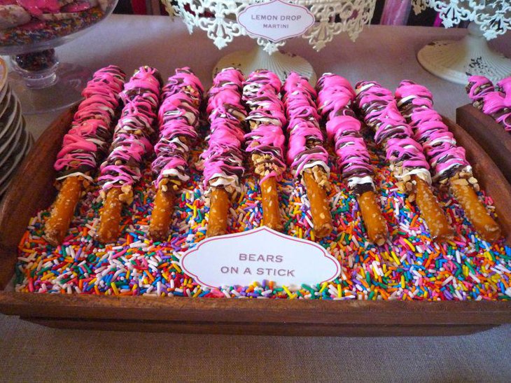 Gorgeous wedding dessert table decor with pink chocolate sticks and colourful candies