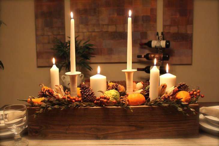 Gorgeous wooden candle holder with candles pines and squash centerpiece for dining table