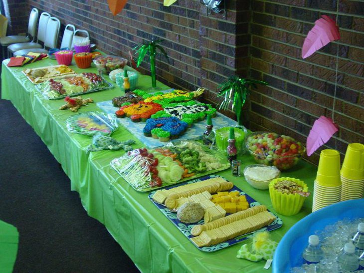 Green buffet table with food for baby shower jungle theme