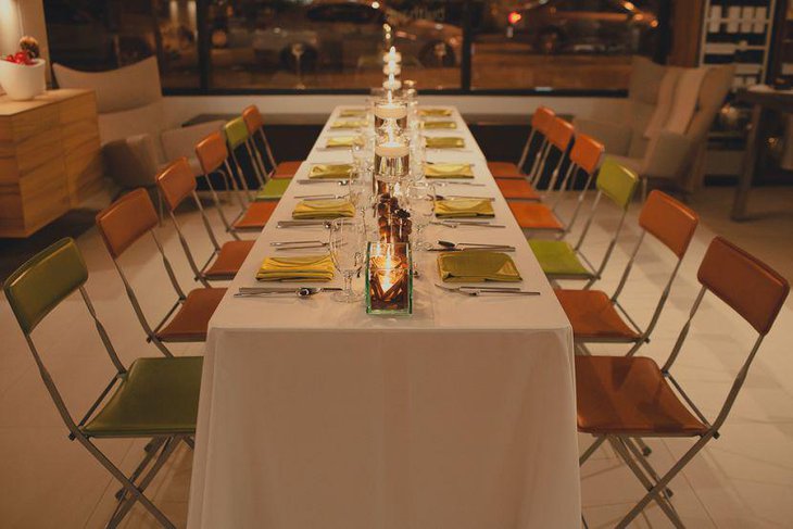 Holiday party table setting with glass holders candles chestnuts and pine cones