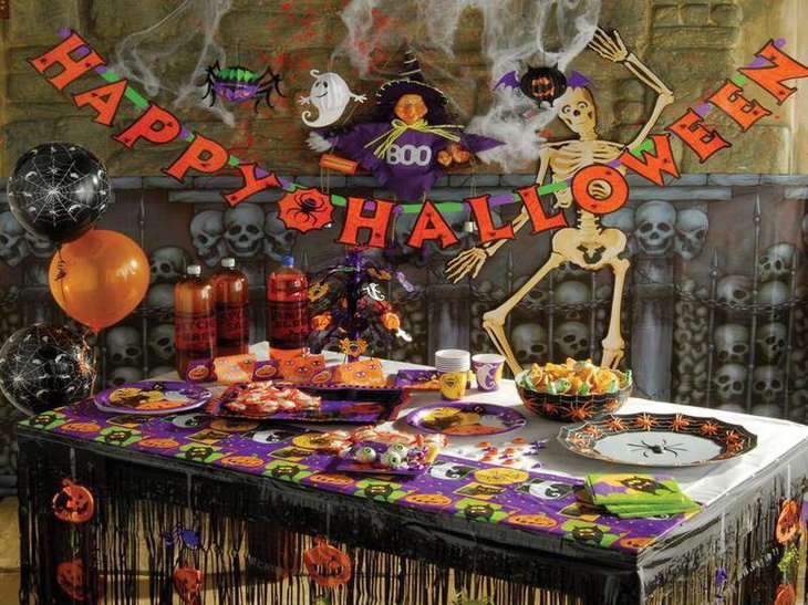 Kids Halloween table decor with spiders on plate and pumpkin cuts outs