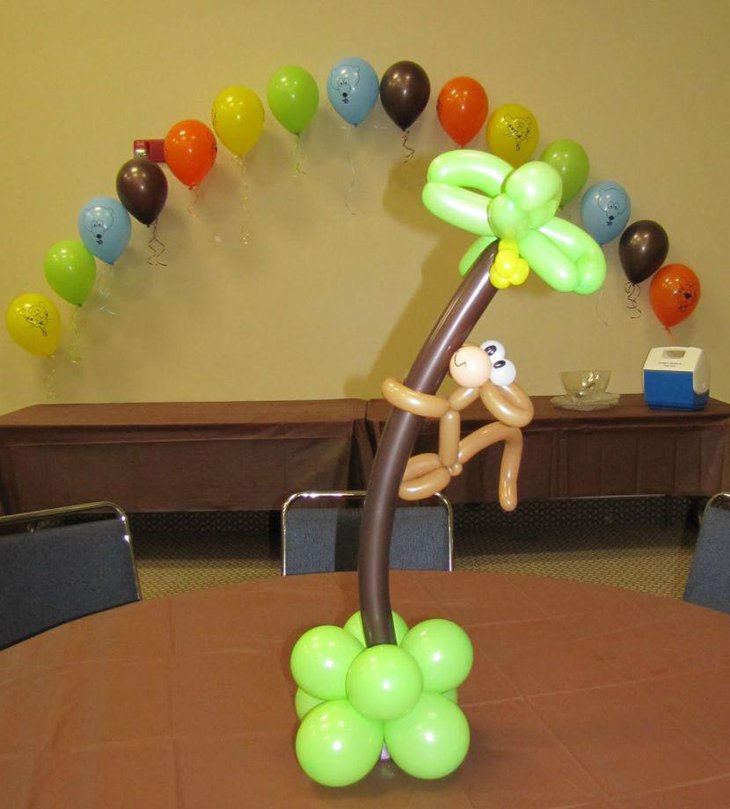 Monkey hanging on coconut tree centerpiece made of balloons for safari baby shower