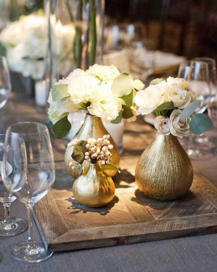 Pear shaped guilded golden vase decor on summer wedding table