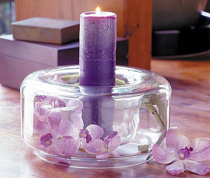 Purple wedding centerpiece with pillar candle and flowers