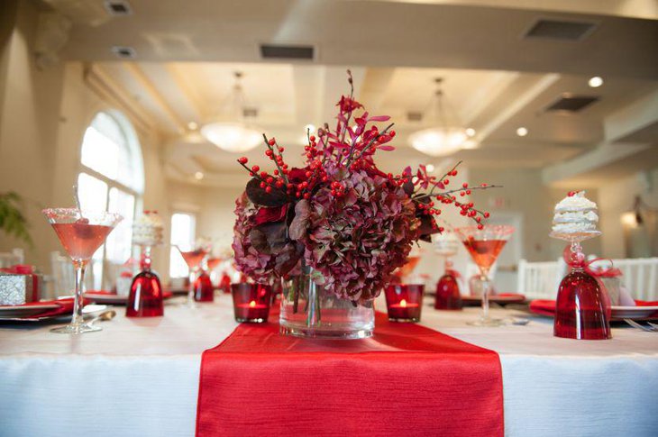 Red berry sticks and floral arrangement as dining table centerpiece