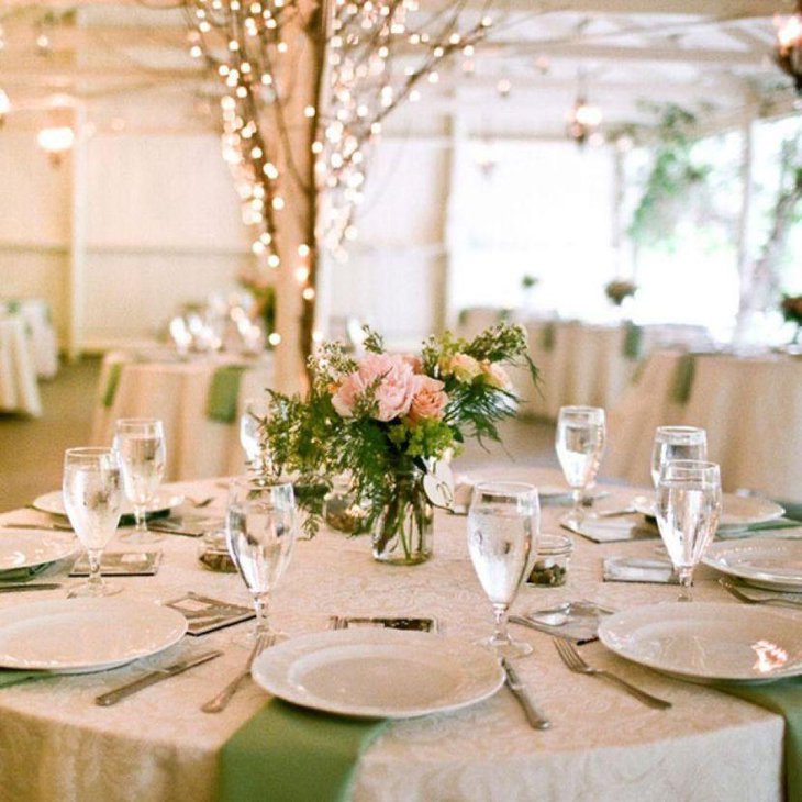 Romantic country wedding reception table decked with floral centerpiece