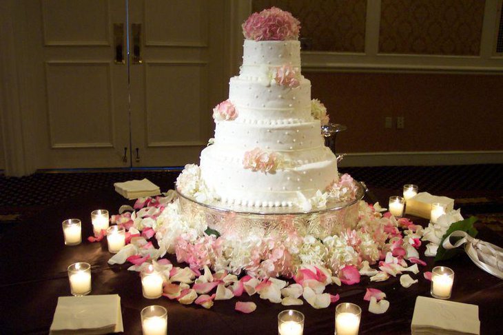 Round wedding cake table decorations using flowers and candle votive