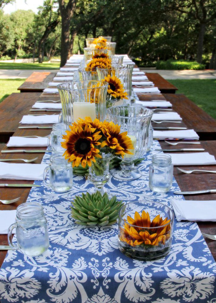 Rustic table decorated with blue printed runner and yellow sunflowers