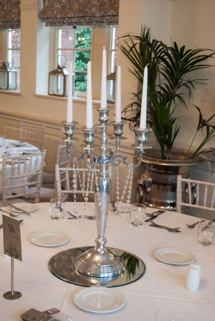Silver candelabra centerpiece decorated with crystal garlands
