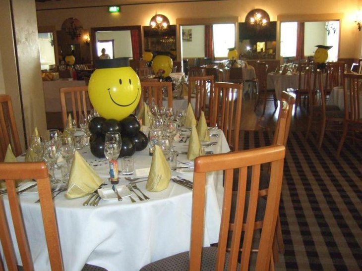 Smiley balloon graduation centerpiece on table