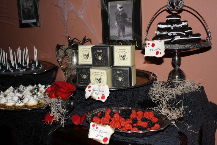 Spooky Halloween party dessert table decor with spider cupcakes and raspberries