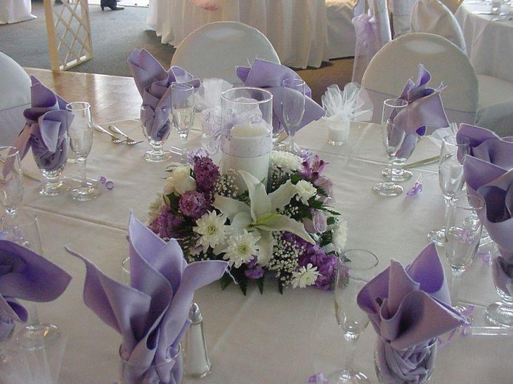 Stunning purple and white floral candle centerpiece for wedding table