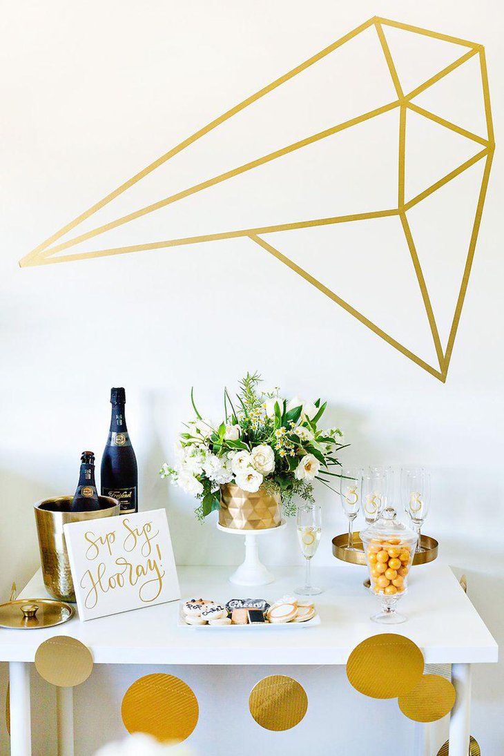 Suave bridal shower dessert table in gold and white tones