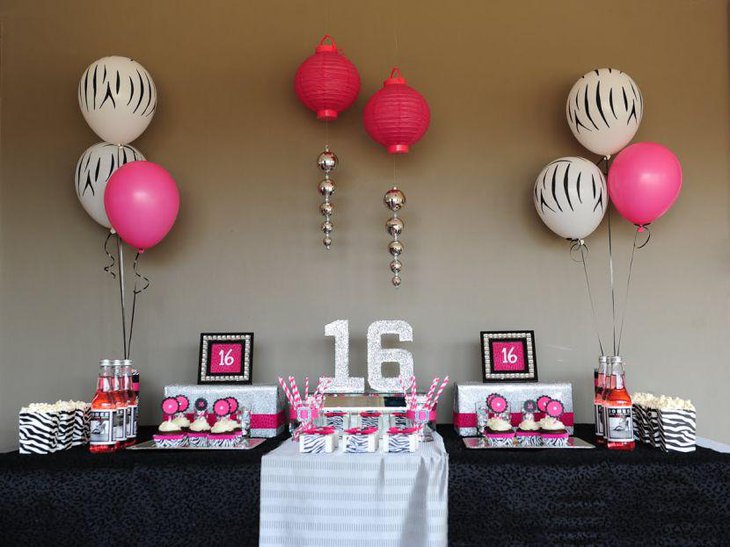 Sweet 16 birthday table decked up with pink balloons and cupcake toppers