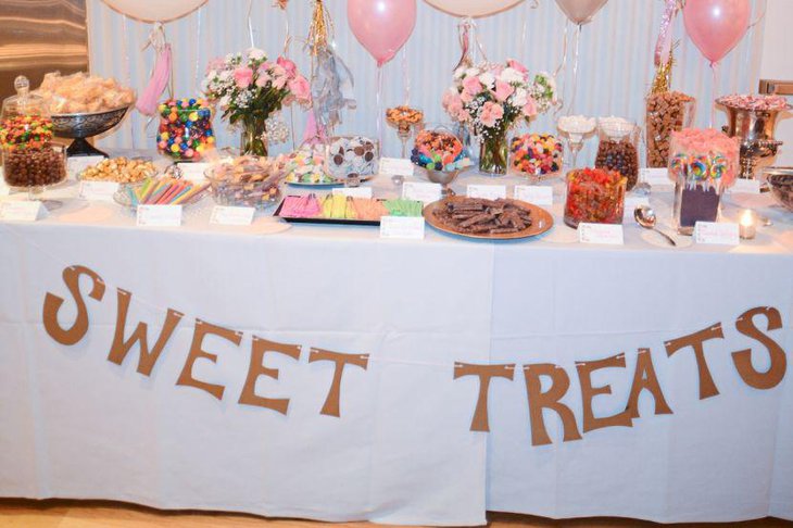 Sweet DIY wedding candy table idea with glass jars filled with flowers and candies