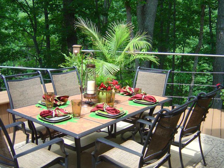 This patio Italian table looks lively with palm and iron candle lamp
