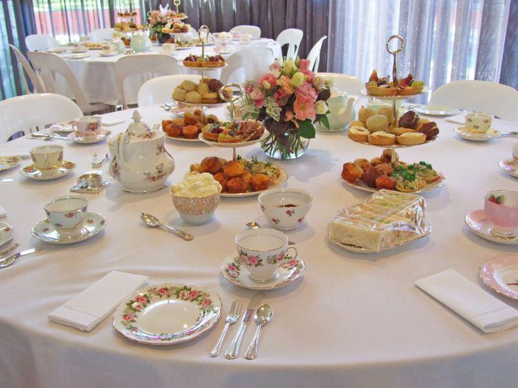This vintage themed 80th birthday table looks elegant with tea cups and flowers