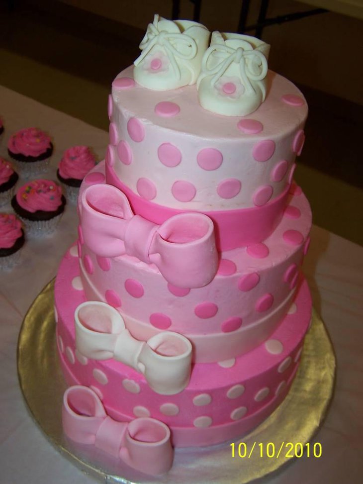 Three tier baby shower cake with cute baby shoes on top