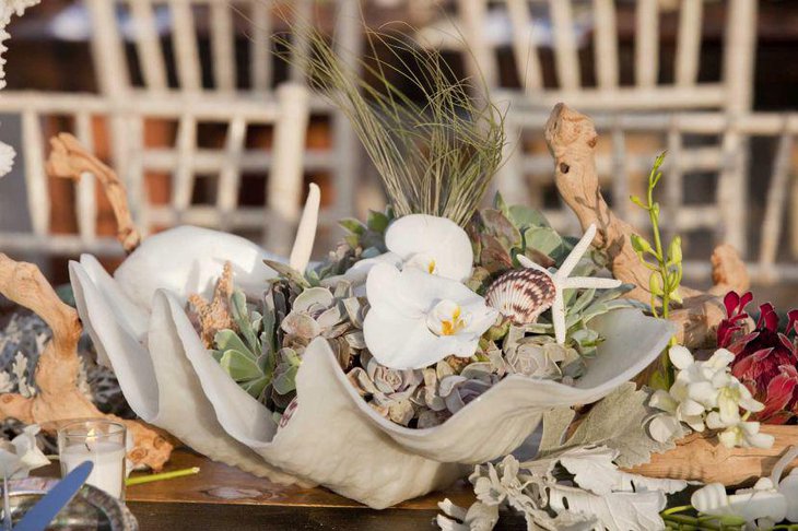 Unique abalone shell centerpiece with greens on summer wedding table