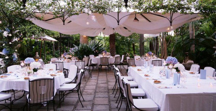 Unique outdoor wedding table setup with floral centerpieces and candles